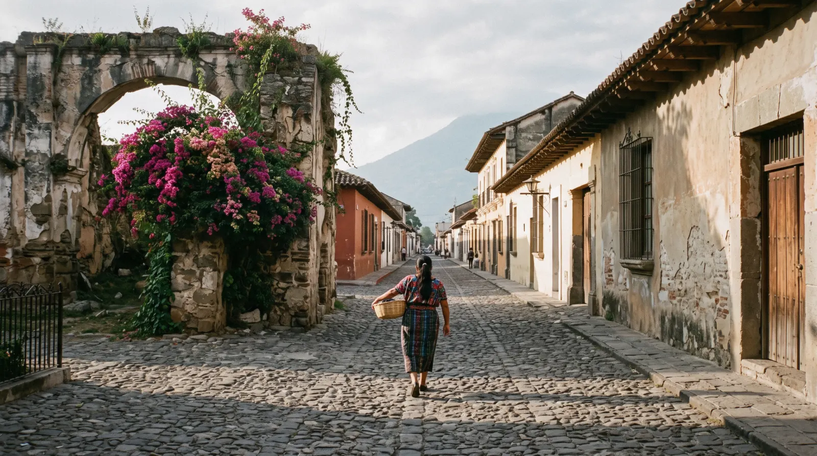 Cobblestone street in Antigua Guatemala with the Santa Catalina Arch under a bright sky