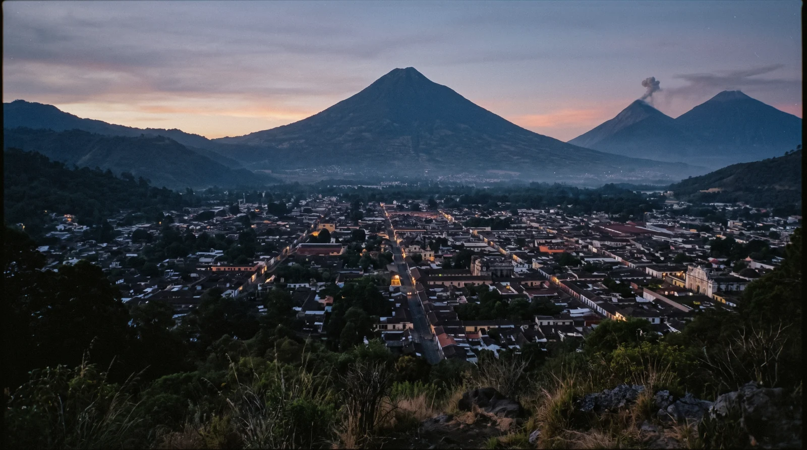 The colonial grid of Antigua Guatemala seen from above with Volcan de Agua behind, the view that answers whether the city is worth visiting